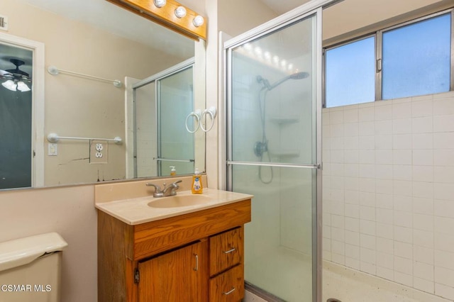 bathroom with toilet, vanity, and walk in shower