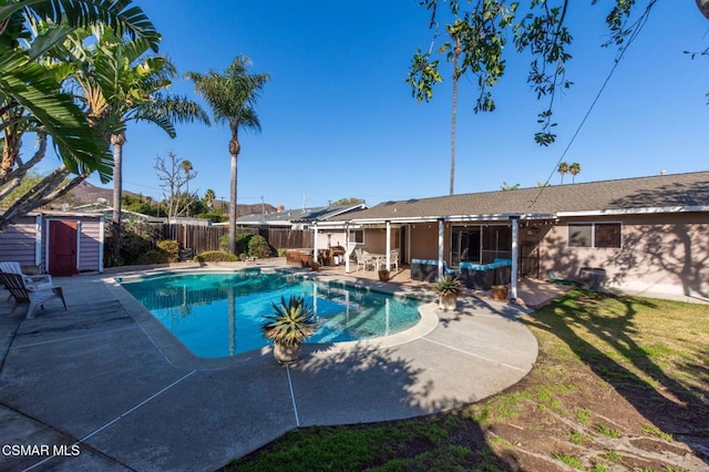 view of swimming pool with a storage shed and a patio