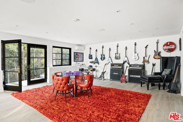 dining room with a wall mounted AC and light hardwood / wood-style floors