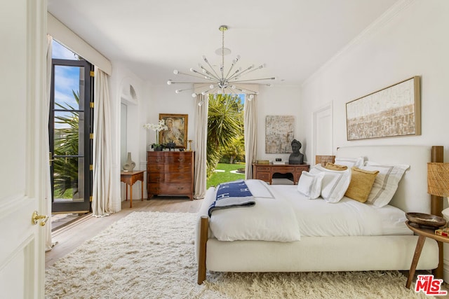 bedroom with crown molding, a notable chandelier, and light wood-type flooring