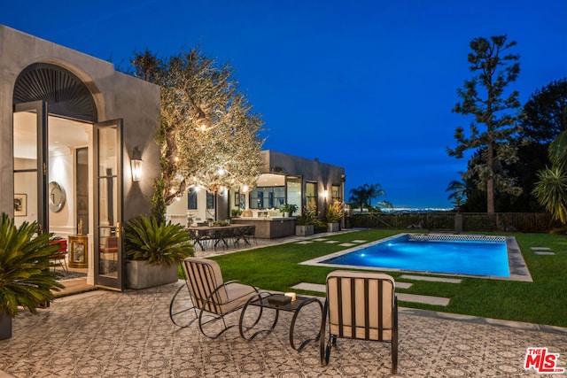 view of swimming pool featuring exterior kitchen and a patio