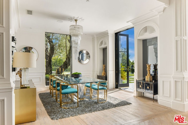 interior space featuring an inviting chandelier, light parquet flooring, ornamental molding, and expansive windows