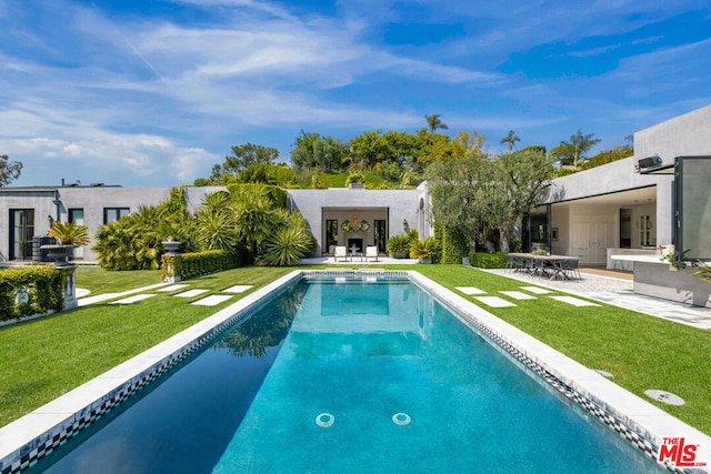 view of swimming pool with a patio and a yard