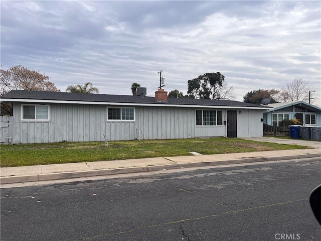 view of front of home featuring cooling unit and a front yard