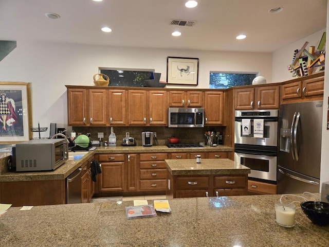 kitchen featuring appliances with stainless steel finishes, a center island, and decorative backsplash