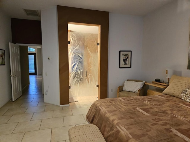 bedroom featuring light tile patterned flooring and connected bathroom