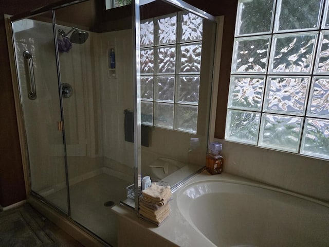 bathroom with a wealth of natural light and shower with separate bathtub