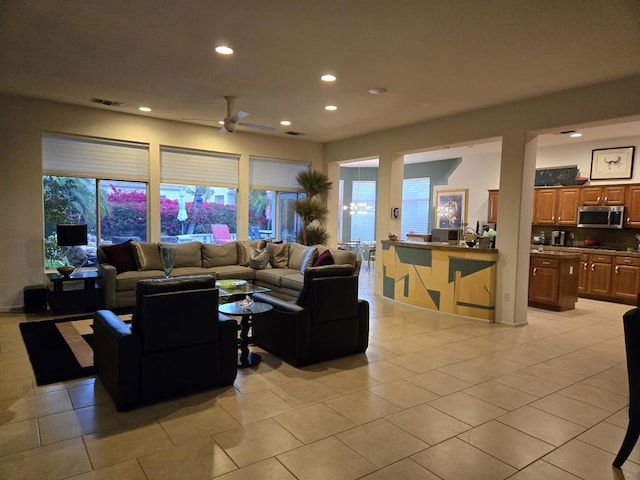 tiled living room with a wealth of natural light and ceiling fan