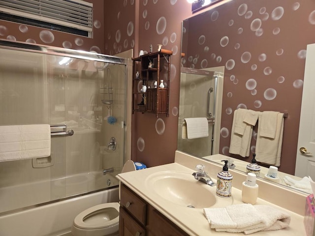 full bathroom featuring toilet, vanity, and bath / shower combo with glass door