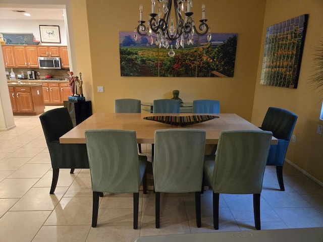 dining space with light tile patterned flooring and an inviting chandelier