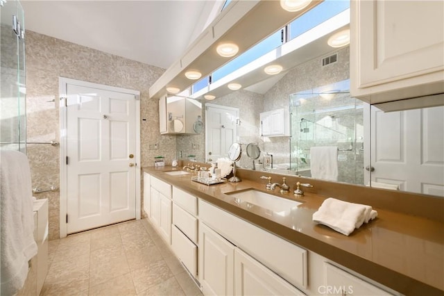 bathroom featuring lofted ceiling, tile patterned flooring, backsplash, vanity, and walk in shower