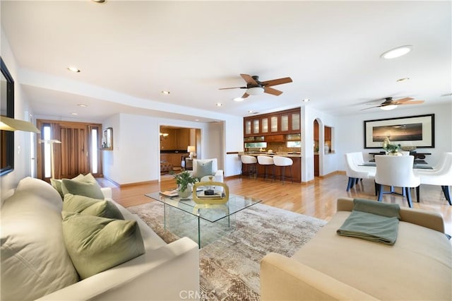 living room featuring ceiling fan and light wood-type flooring