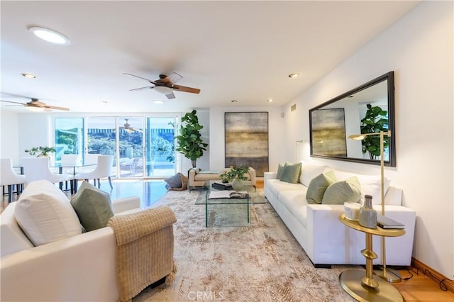 living room with expansive windows and ceiling fan