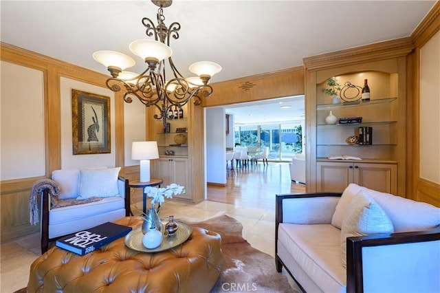 living room with crown molding, wooden walls, built in features, and an inviting chandelier