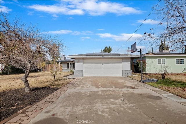 single story home with a garage and solar panels