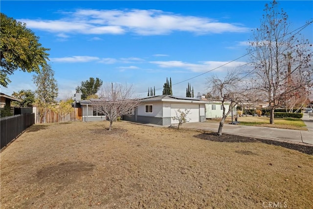 rear view of property featuring a garage and a lawn