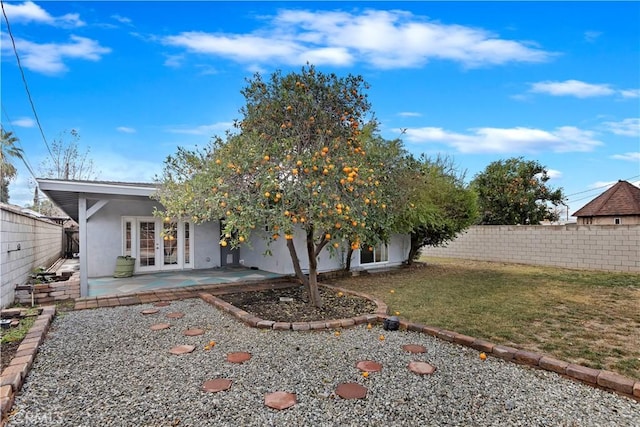 back of house featuring a patio area, french doors, and a lawn