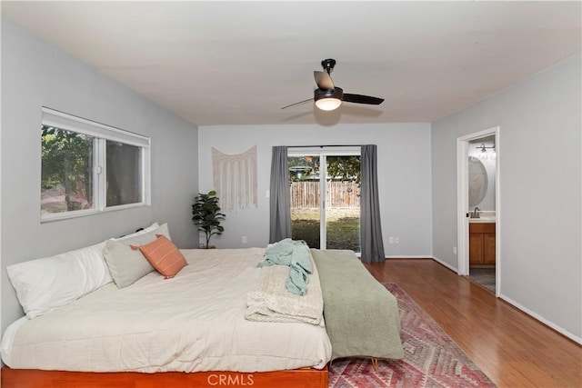 bedroom featuring dark hardwood / wood-style flooring, access to exterior, ensuite bath, and ceiling fan