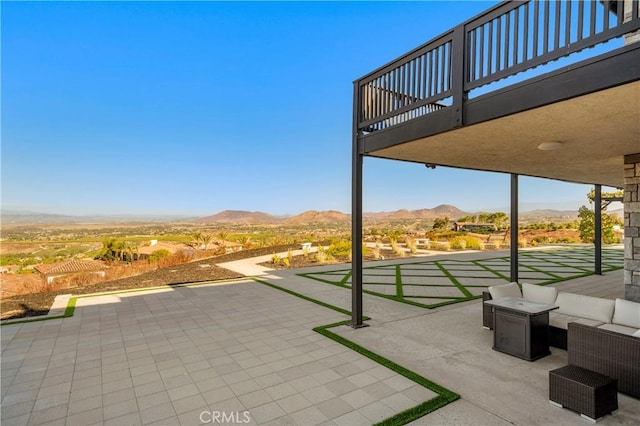 view of patio with a balcony, outdoor lounge area, and a mountain view