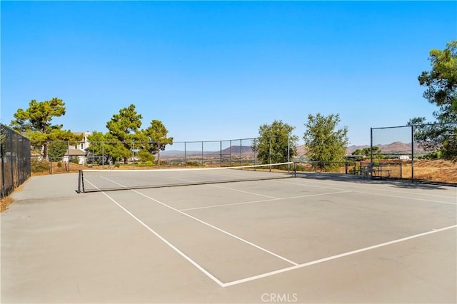 view of tennis court featuring a mountain view