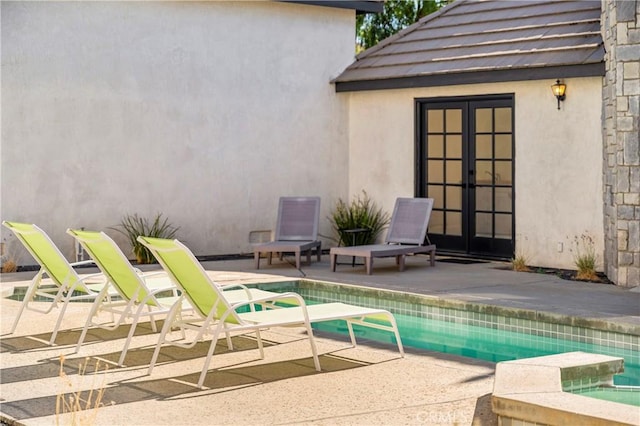 view of swimming pool with french doors and a patio area