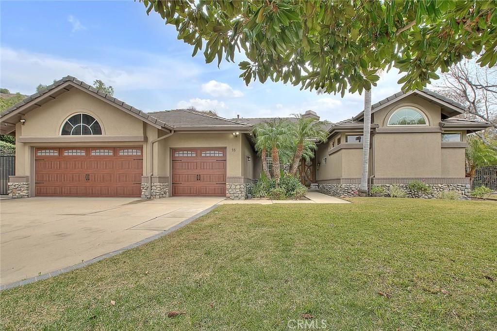 view of front of home with a garage and a front lawn