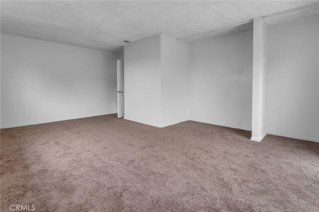 empty room featuring carpet flooring and a textured ceiling