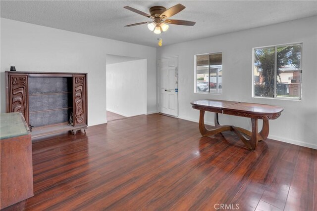 interior space featuring baseboards, a ceiling fan, and wood finished floors