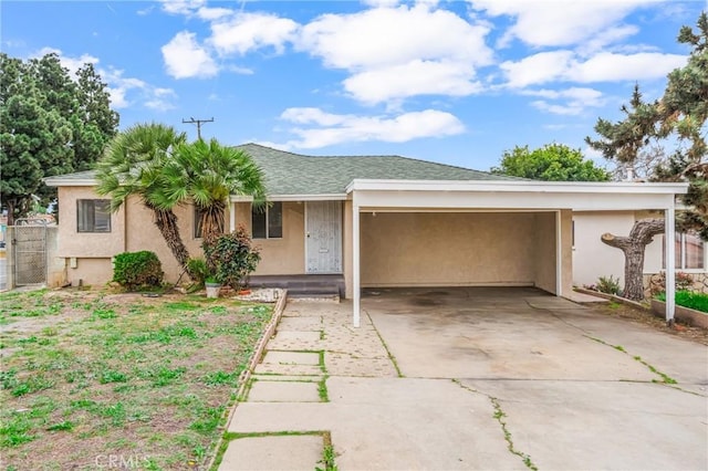 ranch-style home featuring driveway, fence, stucco siding, and an attached carport