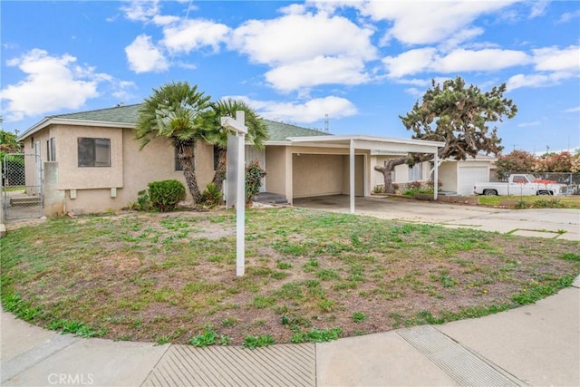 ranch-style home with stucco siding, concrete driveway, fence, and an attached carport