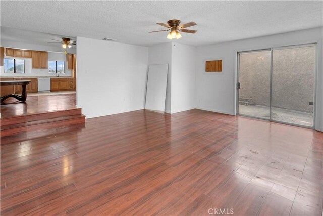 unfurnished living room with wood finished floors, a textured ceiling, and a ceiling fan