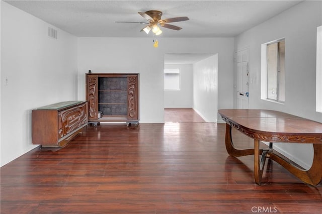 interior space with ceiling fan, wood finished floors, and visible vents