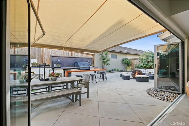 view of patio / terrace featuring a grill, a fire pit, and an outdoor bar