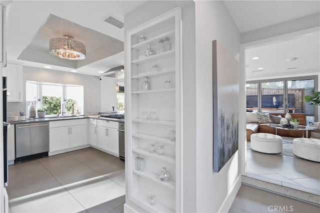 kitchen with white cabinetry, appliances with stainless steel finishes, plenty of natural light, and light tile patterned flooring