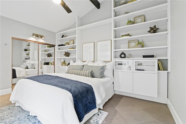 tiled bedroom featuring vaulted ceiling with beams, ceiling fan, and a closet