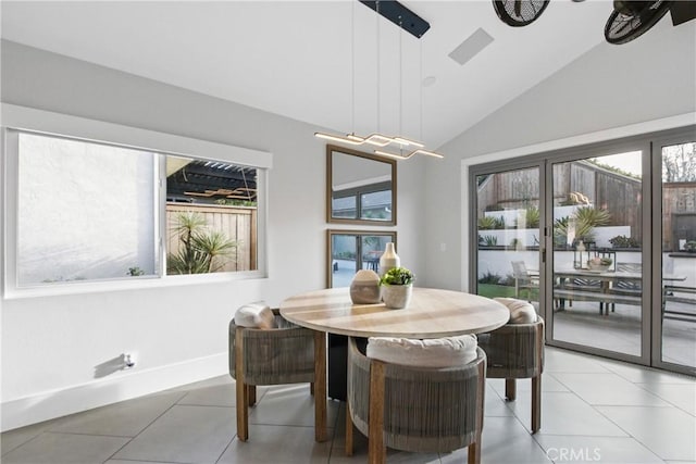 tiled dining space with vaulted ceiling