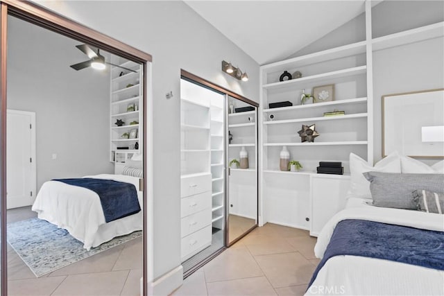 bedroom with lofted ceiling, light tile patterned floors, ceiling fan, and a closet