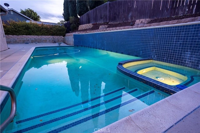 view of swimming pool featuring an in ground hot tub