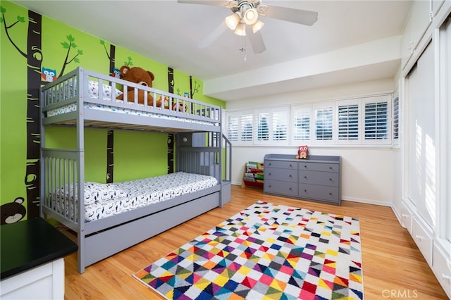 bedroom with hardwood / wood-style flooring, ceiling fan, and a closet