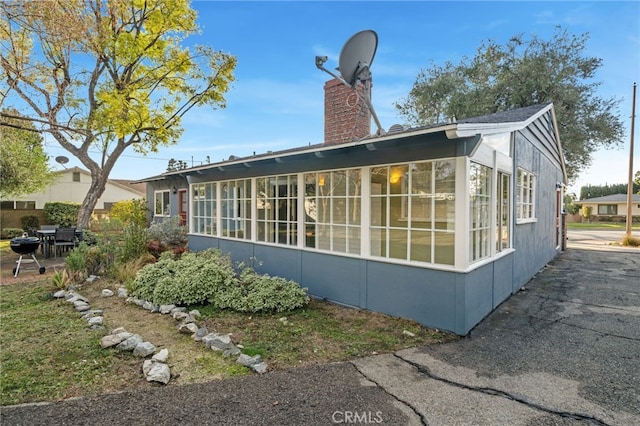 view of property exterior featuring a sunroom