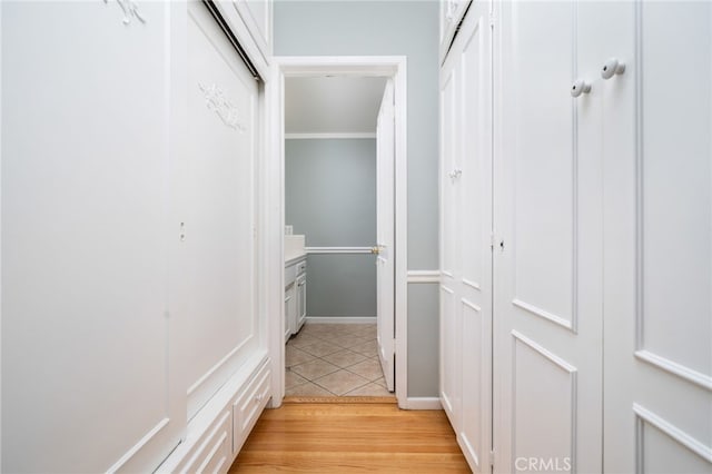 walk in closet with light hardwood / wood-style flooring