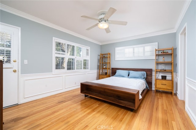 bedroom featuring crown molding, light wood-type flooring, and ceiling fan