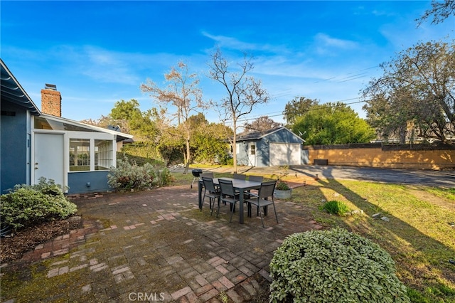 view of patio / terrace featuring a garage and an outbuilding