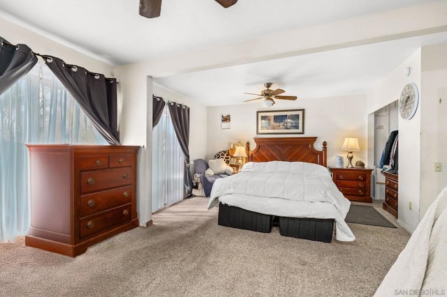 bedroom featuring multiple windows, light carpet, and ceiling fan