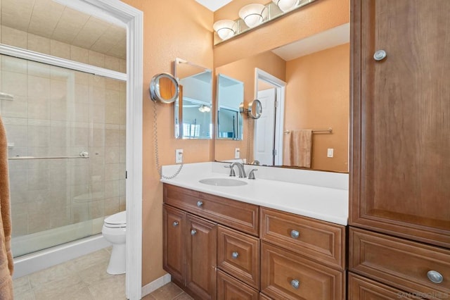 bathroom with vanity, a shower with door, and toilet