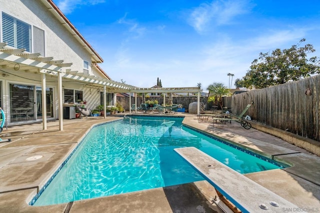 view of pool with a pergola, a patio area, and a diving board