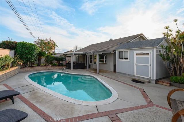 view of swimming pool featuring an outbuilding and a patio