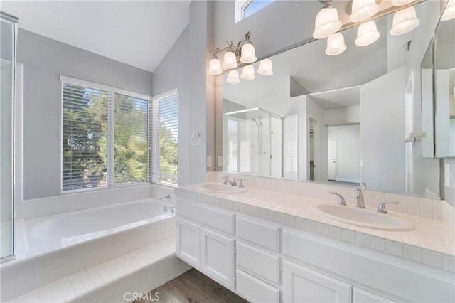 bathroom featuring a healthy amount of sunlight, lofted ceiling, separate shower and tub, and wood-type flooring