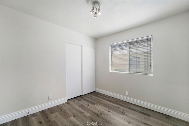 unfurnished bedroom featuring light hardwood / wood-style flooring and a closet