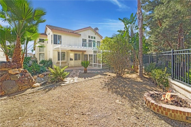 rear view of house with a pergola, a fire pit, and a patio